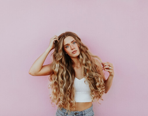 young woman with long curly hair posing