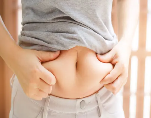 woman holding her abdominal fat