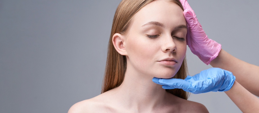 young woman receiving examination for a face treatment