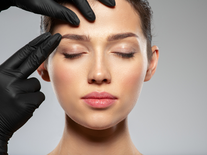 young woman's face being checked for a facial treatment 