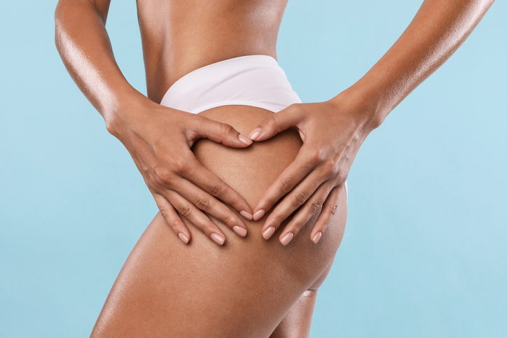 Woman making heart sign gesture on buttocks