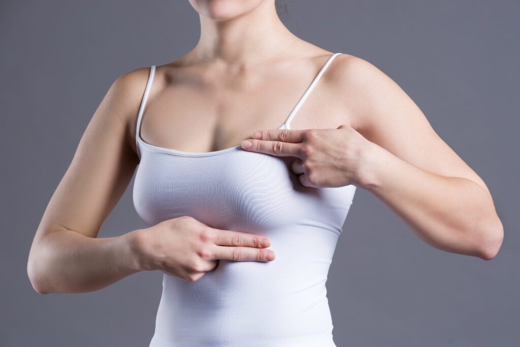 young woman doing a breast examination 