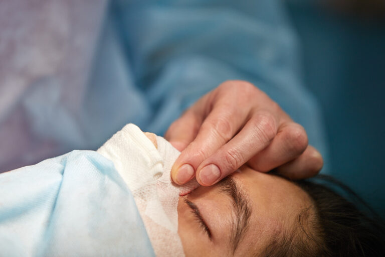 woman immediately after a rhinoplasty surgery with a bandage on her nose